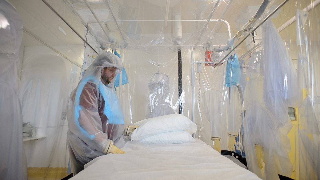 Homem usa roupas de proteção nas instalações do Hospital Royal Free, ao norte de Londres, durante preparação para um teste em um paciente contaminado pelo vírus Ebola