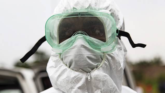Enfermeiro trabalha na remoção e enterro de uma vítima de Ebola no Estado da Virgínia, nos arredores de Monrovia, na Libéria