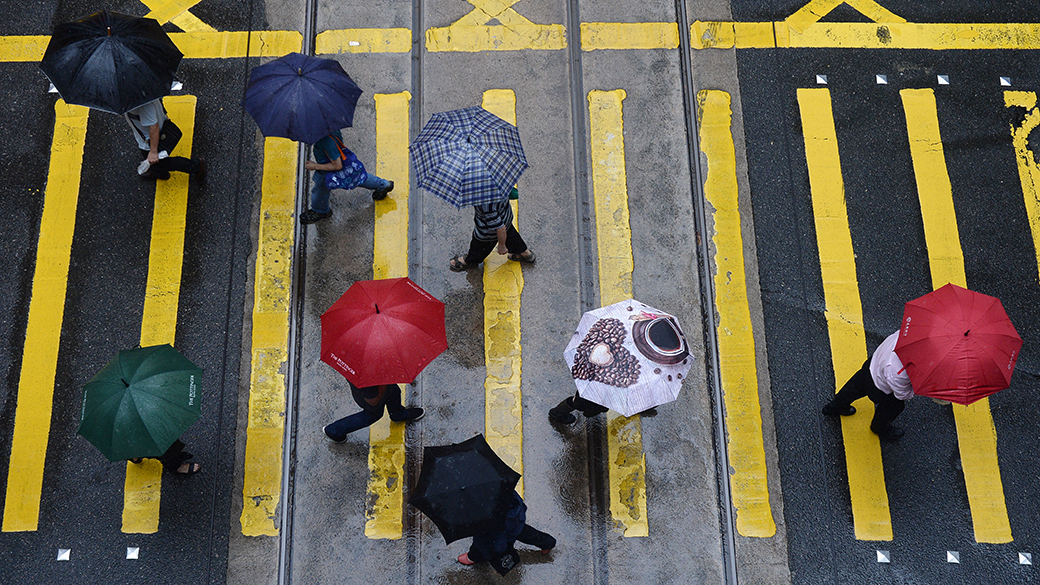 Pedrestres atravessam cruzamento durante chuva em Hong Kong, na China