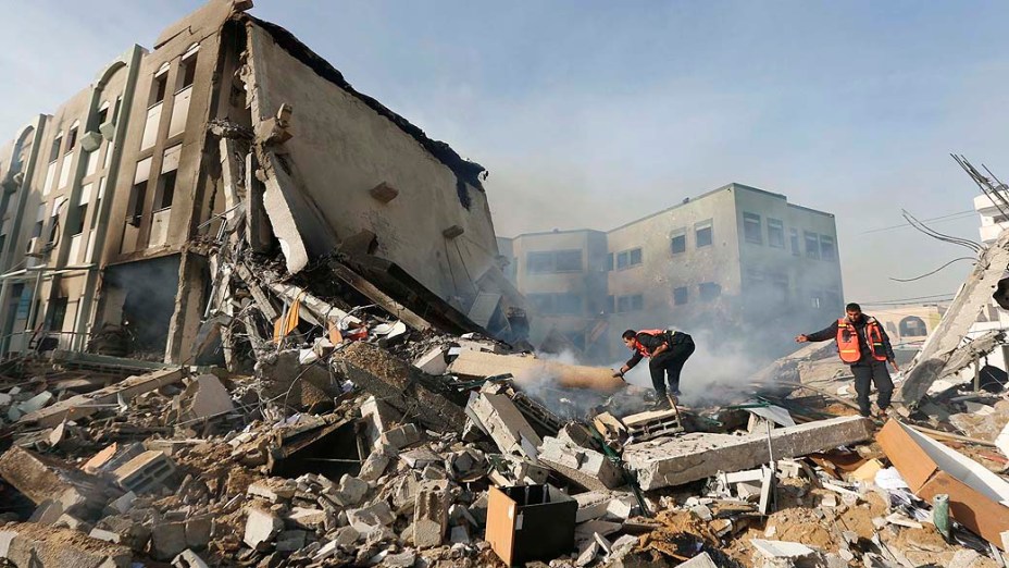 Bombeiros palestinos tentam apagar incêndio após ataque aéreo israelense contra o edifício do Ministério do Interior, na cidade de Gaza