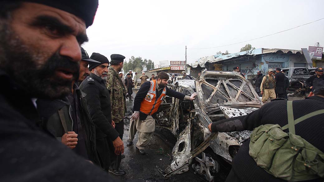 No Paquistão, policiais tentam remover carro após ataque em Peshawar, ao menos 15 pessoas morerram