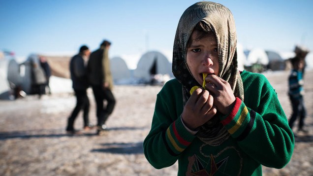 Criança síria brinca em campo de refugiados na fronteira entre Turquia e Síria, próximo à cidade de Azaz