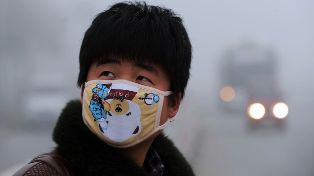 Jovem usa máscara para se proteger da poluição em Pequim, onde os níveis alarmantes de sujeira no ar fizeram com que as vendas de produtos desse tipo disparassem