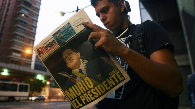 Jovem lê jornal local no dia seguinte à morte do presidente da Venezuela Hugo Chávez, em Caracas