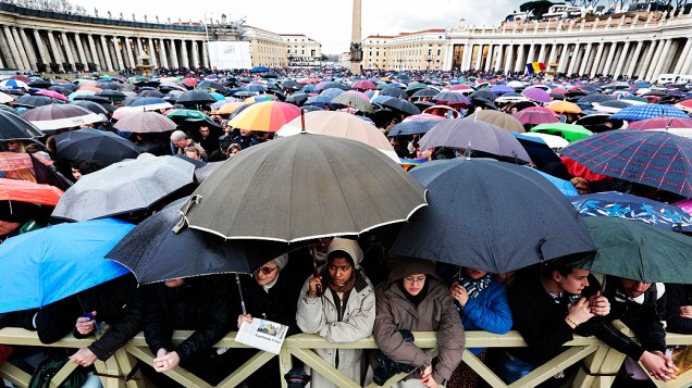 Sob chuva, os fiéis esperam na Praça de São Pedro o possível anúncio do novo Papa