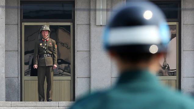 Soldados da Coreia do Norte (e) e do Sul vigiam a zona desmilitarizada, que separa os dois países