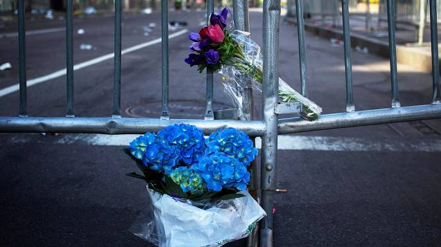 Flores são deixadas nesta terça-feira (16) na grade que bloqueia a Boylston Street, perto da linha de chegada da Maratona de Boston