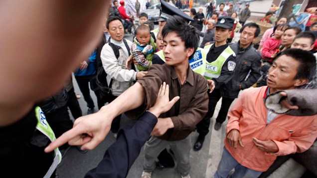 Sobrevivente do terremoto  enfrenta um policial que estava tentando controlar um protesto contra a falta de operações de resgate na aldeia de Chaoyang, depois do terremoto de sábado, em Lushan condado de Yaan, na China