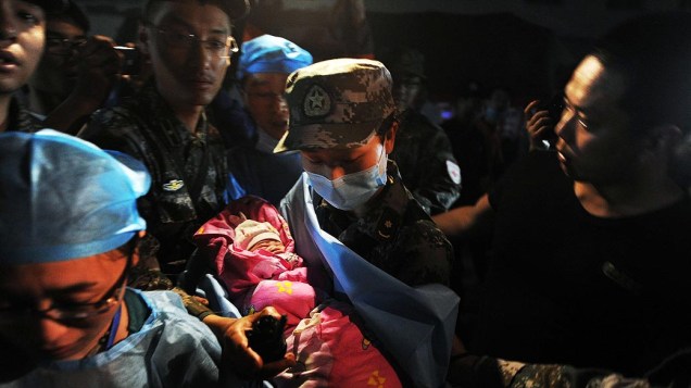 Recém-nascido em uma tenda de socorro é atendido pela equipe médica após o terremoto que atingiu  o condado de Lushan, na província de Sichuan, China