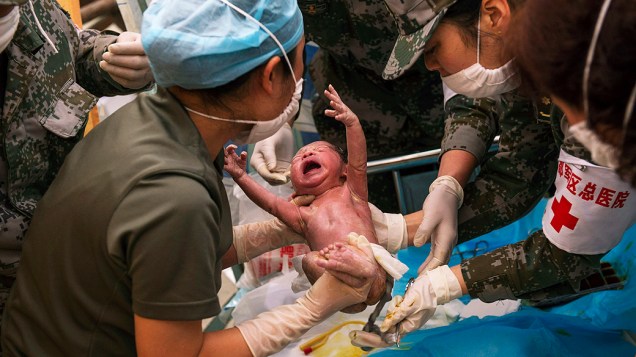 Médicos chineses cuidam de um recém-nascido em uma tenda que funciona como hospital temporário em Taiping, no sudoeste da China, região atingida pelo forte terremoto do último sábado (20)