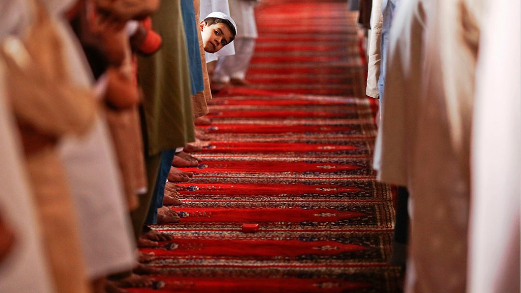 Menino observa orações da sexta-feira na mesquita de Wazir Khan, em Lahore, no Paquistão