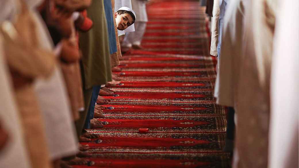 Menino observa orações da sexta-feira na mesquita de Wazir Khan, em Lahore, no Paquistão