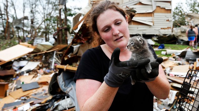 Mulher segura gato resgatado dos escombros de casas destruídas por tornado que atingiu o estado de Oklahoma, nos EUA