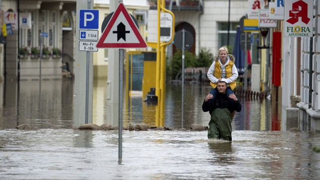 Homem carrega mulher nos ombros em uma rua inundada em Gera. Autoridades enviaram brigadas de soldados para participar do trabalho de contenção de inundação de vários rios, depois de fortes chuvas nos últimos dias, na Alemanha