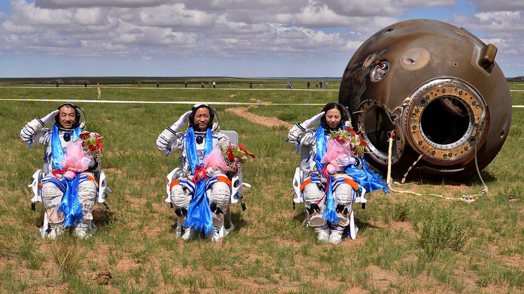 Astronautas Zhang Xiaoguang, Nie Haisheng e Wang Yaping chegam à Terra na cápsula da nave espacial Shenzhou 10