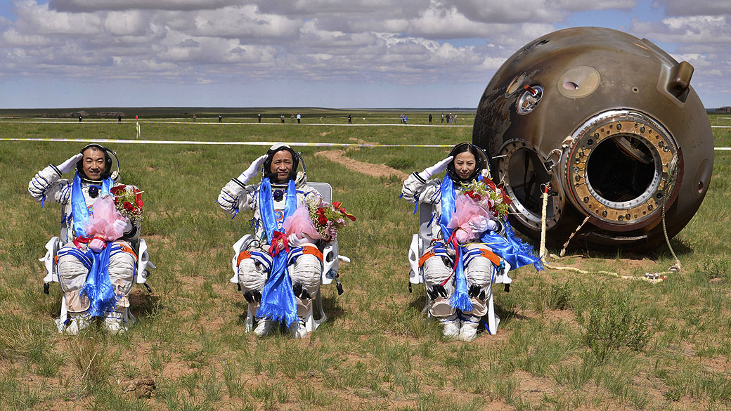 Astronautas Zhang Xiaoguang, Nie Haisheng e Wang Yaping chegam à Terra na cápsula da nave espacial Shenzhou 10