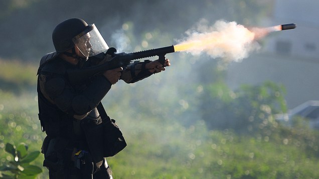 Policial joga uma bomda de gás lacrimogêneo contra manifestantes no perímetro de segurança de dois quilômetros do estádio Castelão, em Fortaleza, onde Espanha e Itália jogam semifinal da Copa das Confederações, em 27 de junho