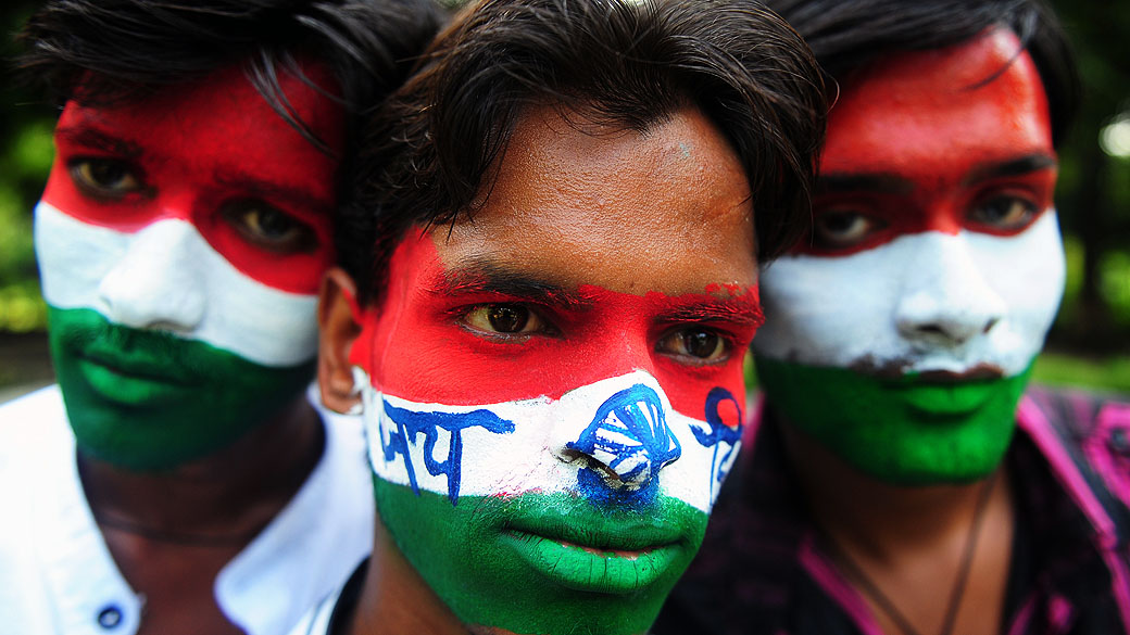 Estudantes pintam seus rostos com as cores da bandeira indiana, na véspera do Dia da Independência em Allahabad