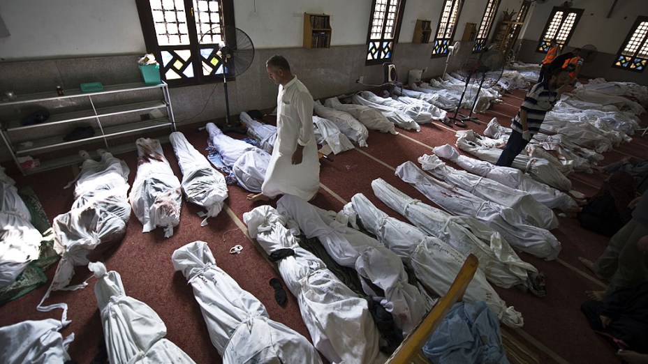 Homem caminha entre corpos nesta quinta-feira(15), em uma mesquita no Cairo, depois de uma repressão sobre os acampamentos de protesto dos partidários do deposto presidente islâmico Mohamed Mursi, no Egito