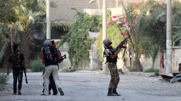 Rebelde sírio aponta arma contra soldados do Exército em zona industrial de Deir Ezzor, nesta segunda-feira (02). O governo da Síria pediu hoje à ONU que impeça a ação militar