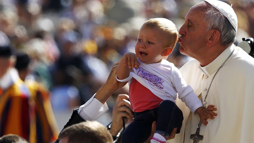 Papa Francisco beija uma criança na chegada para a audiência geral na Praça de São Pedro, no Vaticano, nesta quarta-feira (18)