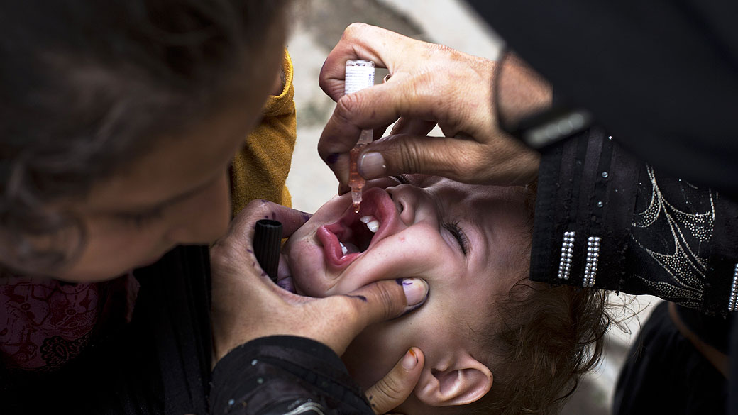 Médico aplica vacina em Rawalpind, no Paquistão. Bomba explodiu ao lado de van