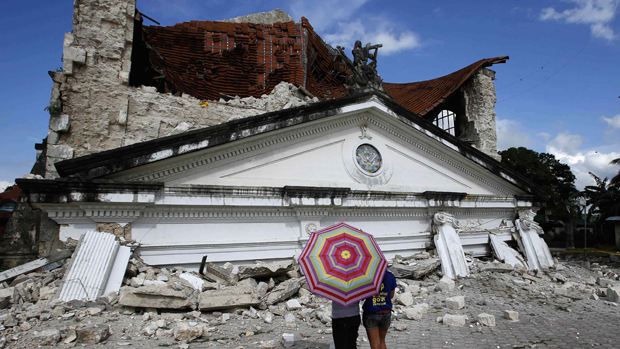 Moradores observam igreja que desmoronou após terremoto que atingiu a região central das Filipinas