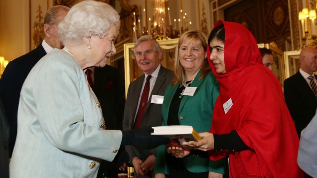 A jovem ativista paquistanesa Malala Yousafzai entrega uma cópia de seu livro para a rainha Elizabeth II, no Palácio de Buckingham, em Londres