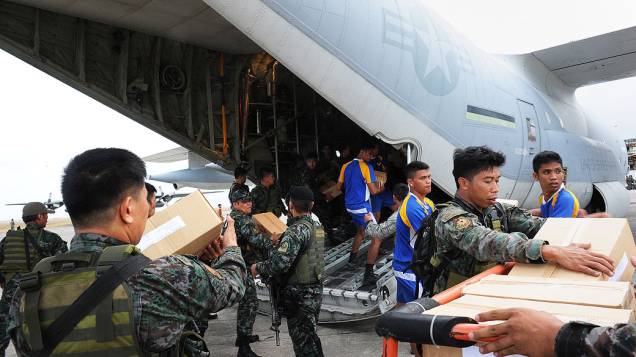 Militares norte-americanos e filipinos enviam alimentos para as vítimas do tufão Haiyan, no aeroporto de Tacloban, na região central das Filipinas