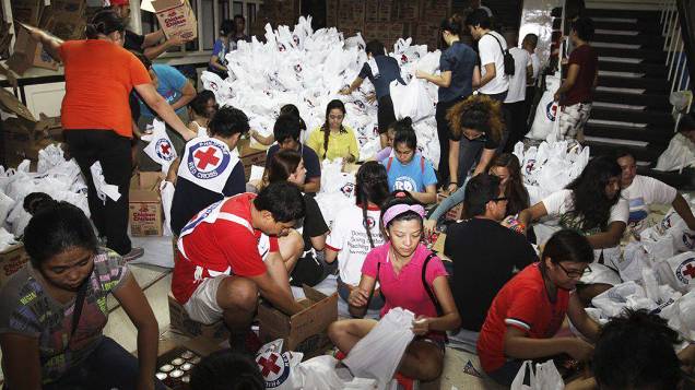 Voluntários embalam alimentos para vítimas do tufão Haiyan em Manila, nas Filipinas