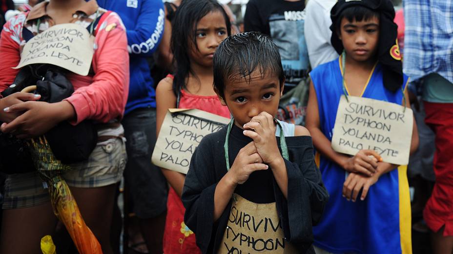 Moradores esperam por comida no aeroporto de Tacloban, nas Filipinas