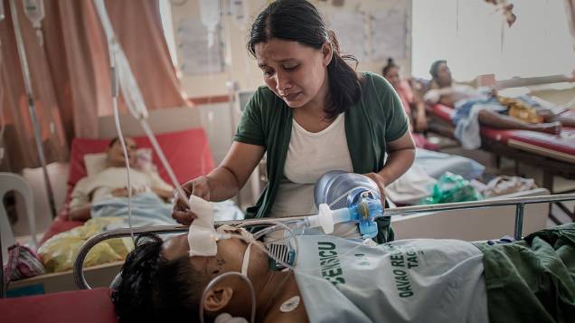 Mulher cuida de seu marido em hospital de Tacloban, nas Filipinas, nesta sexta-feira (15)