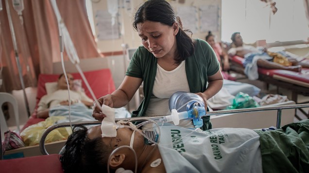 Mulher cuida de seu marido em hospital de Tacloban, nas Filipinas, nesta sexta-feira (15)