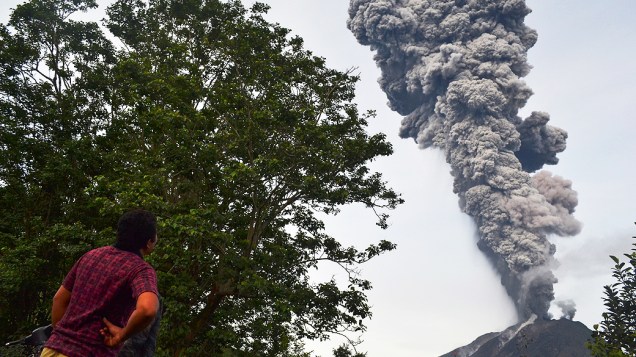 <p>Homem observa fumaça expelida pelo vulcão Sinabung que alcançou 8 km de altura, no distrito de Karo, na Indonésia</p>