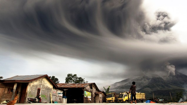 <p>Mulher observa fumaça expelida pelo vulcão Sinabung que alcançou 8 km de altura, no distrito de Karo, na Indonésia</p>