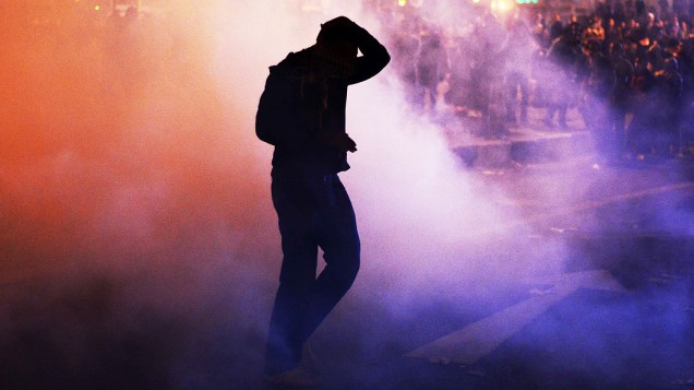 Manifestante recebe gás lacrimogêneo durante confronto que marca o aniversário dos protestos contra os militares em 2011, na praça Tahrir, no Cairo, Egito