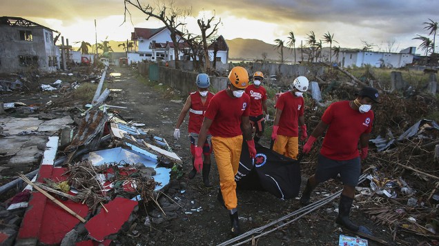 Equipe de resgate da Cruz Vermelha remove corpo de uma vítima do super tulfão Haiyan, em Tacloban, nas Filipinas