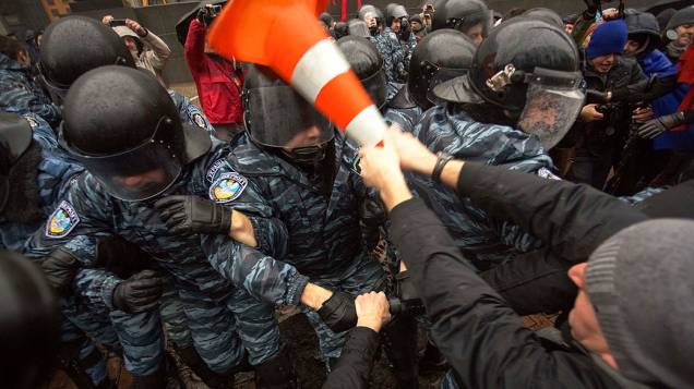 Manifestante entra em confronto com a polícia de choque durante um comício de apoio a integração na União Européia, na frente do gabinete dos ministros em Kiev, na Ucrânia
