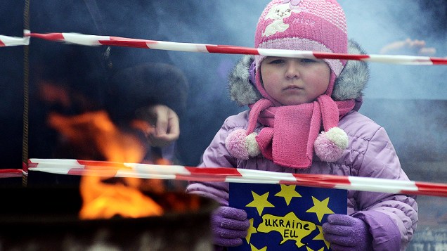 Criança segura cartaz dizendo "Ucrânia-UE" durante uma manifestação do movimento pró-europeu na cidade de Ivano-Frankivsk, em resposta à decisão do governo ucraniano de desfazer um pacto chave com o União Europeia após sofrer pressão da Rússia