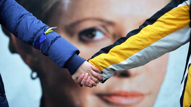 Estudantes dão as mãos simbolizando a união da Ucrânia com a União Europeia em frente de tendas montadas pelos partidários de Yulia Tymoshenko, em Kiev, na Ucrânia