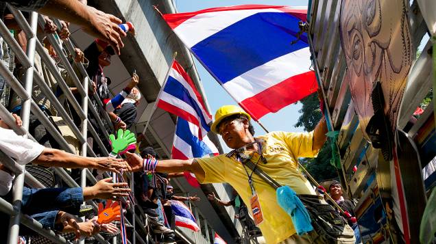 Manifestantes se cumprimentam durante um protesto em frente à sede da polícia central de Bangcoc, na Tailândia