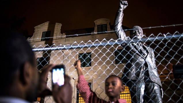 Pai fotografa seu filho em frente a uma estátua de Nelson Mandela na embaixada Sul-Africana, em Washington, nos Estados Unidos
