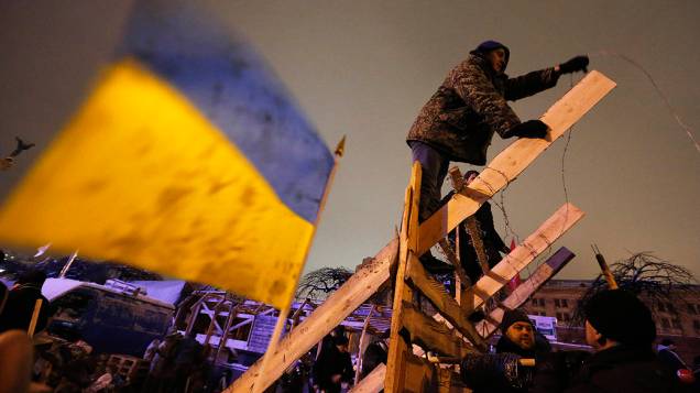 Manifestantes a favor da integração da Ucrânia à União Europeia constroem novas barricadas na Praça da Independência, em Kiev após ação da polícia para retirá-los do local