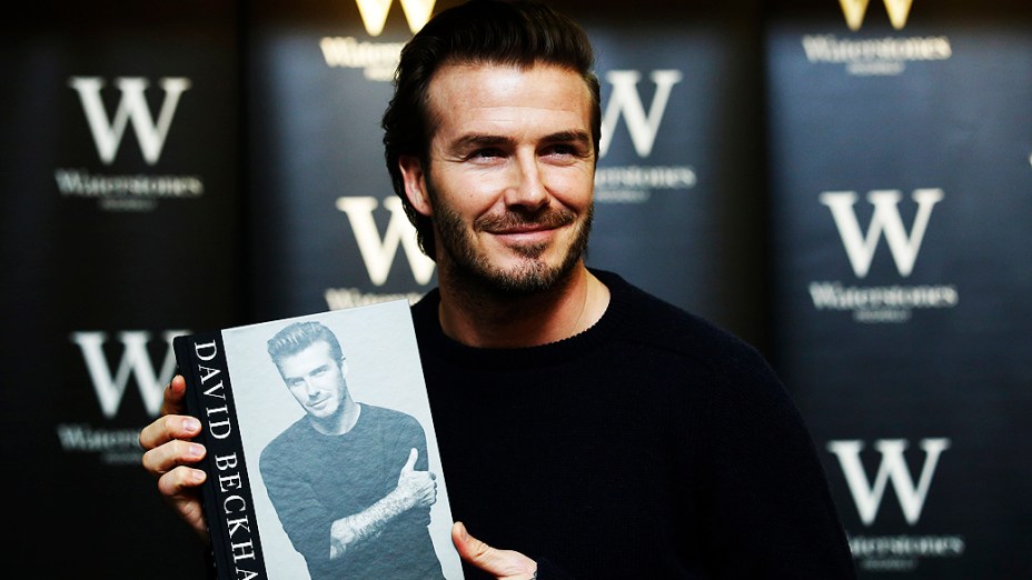 O ex-jogador de futebol David Beckham posa com livro que leva seu nome em uma livraria de Londres, Inglaterra