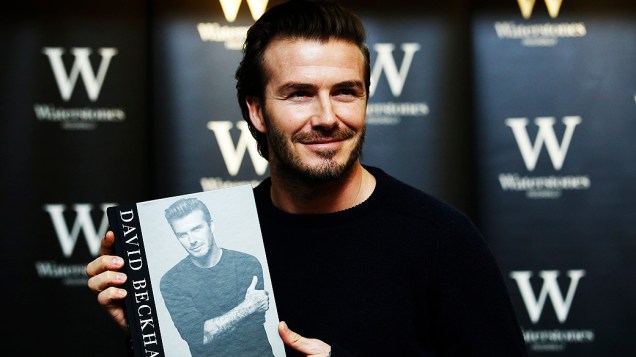 O ex-jogador de futebol David Beckham posa com livro que leva seu nome em uma livraria de Londres, Inglaterra