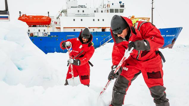 Tripulantes tentam quebrar neve ao redor do navio russo russo MV Akademik Shokalskiy, na Antártida