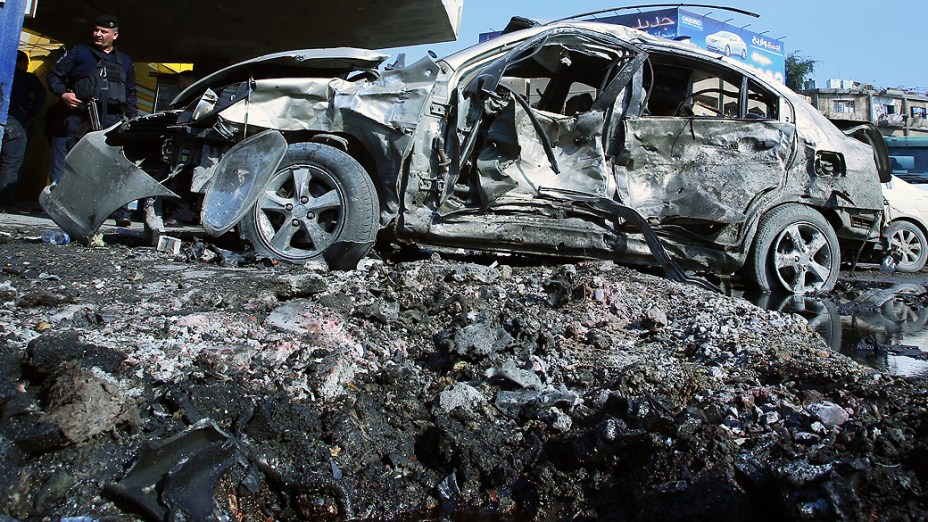 Policial iraquiano observa local de explosão de carro-bomba em Baghdad, no norte do Iraque; dia de violência deixou ao menos 52 mortos pelo país