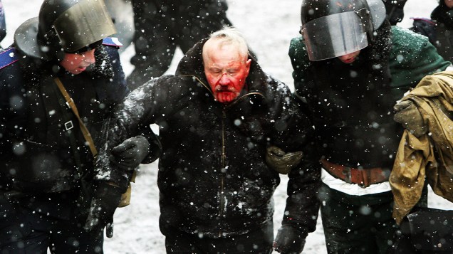 Homem é socorrido durante os confrontos em Kiev