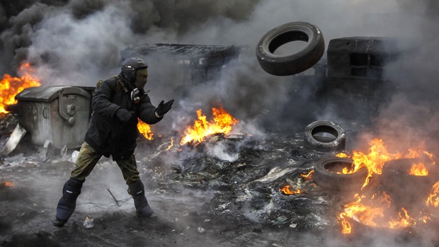 Em Kiev, manifestante pró-Europa lança pneu em barricada