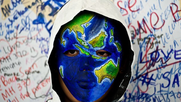 <p>Artista mascarado se coloca nesta segunda-feira (17) diante de cartaz no aeroporto de Sepang, em Kuala Lumpur (Malásia), com mensagens de apoio e orações aos passageiros desaparecidos a bordo do voo 370 da Malaysia Airlines</p> <p>Artista mascarado se coloca nesta segunda-feira (17) diante de cartaz no aeroporto de Sepang, em Kuala Lumpur (Malásia), com mensagens de apoio e orações aos passageiros desaparecidos a bordo do voo 370 da Malaysia Airlines</p>